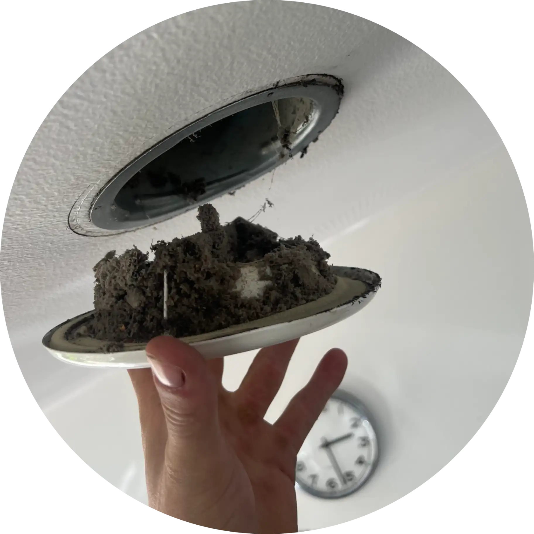Snavset ventilationsrist fuld af støv og skidt holdt af en hånd.